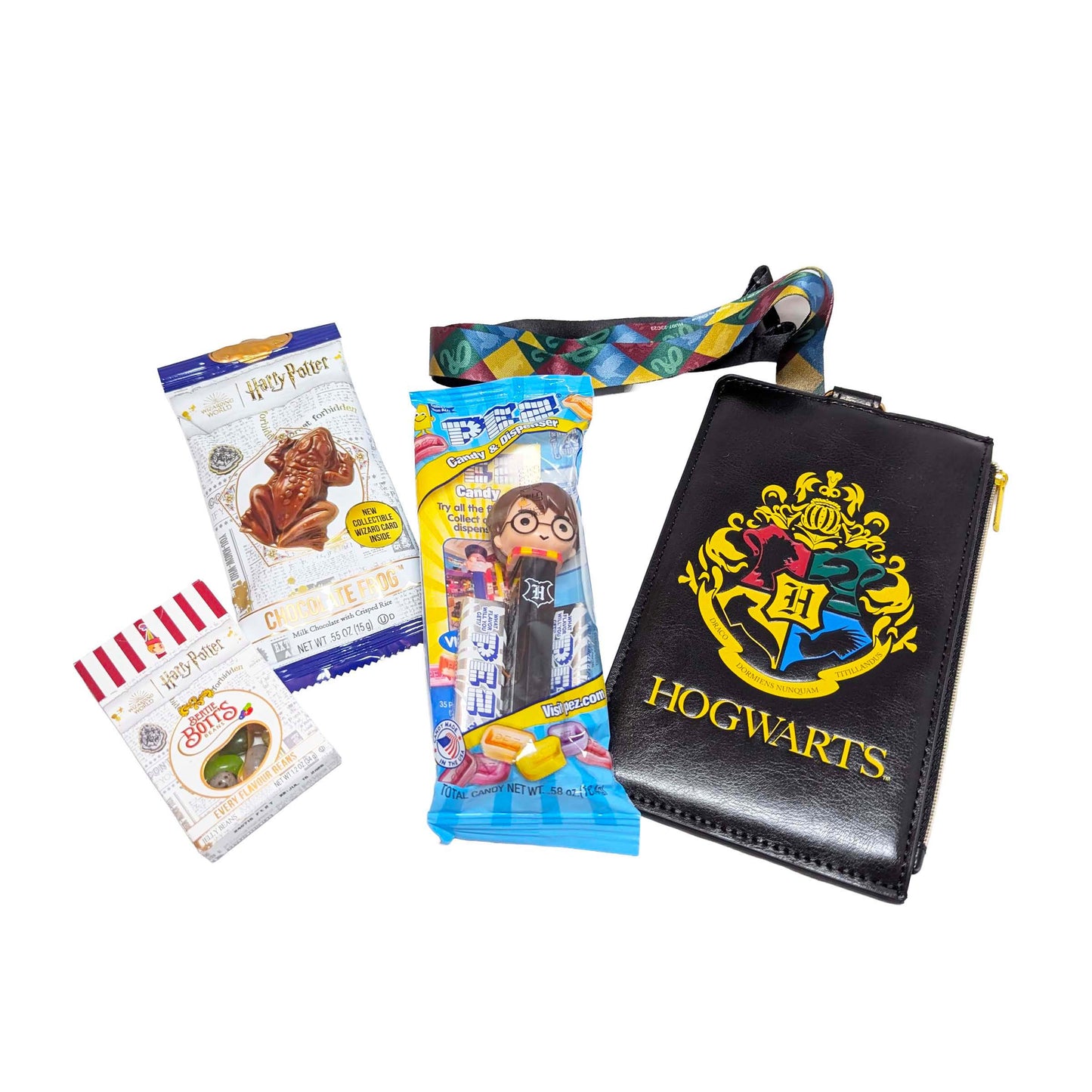 Flat lay arrangement of a deluxe Hogwarts zippered pouch wallet, matching lanyard, a Chocolate Frog, themed PEZ dispenser, and Bertie Bott's Every Flavor Beans for an Orlando resort gift box
