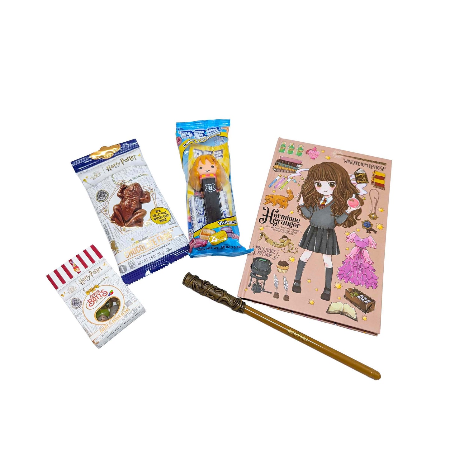 Flat lay arrangement of a licensed Hermione Granger chibi journal, wand pen, a Chocolate Frog, themed PEZ dispenser, and Bertie Bott's Every Flavor Beans for a custom Orlando resort gift box