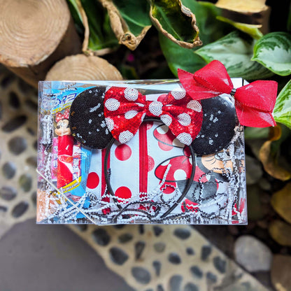 Custom Minnie Mouse gift set featuring a red and black polka dot passport crossbody bag, matching sequined Minnie ears, a Mickey PEZ dispenser, and candies for Orlando resort delivery