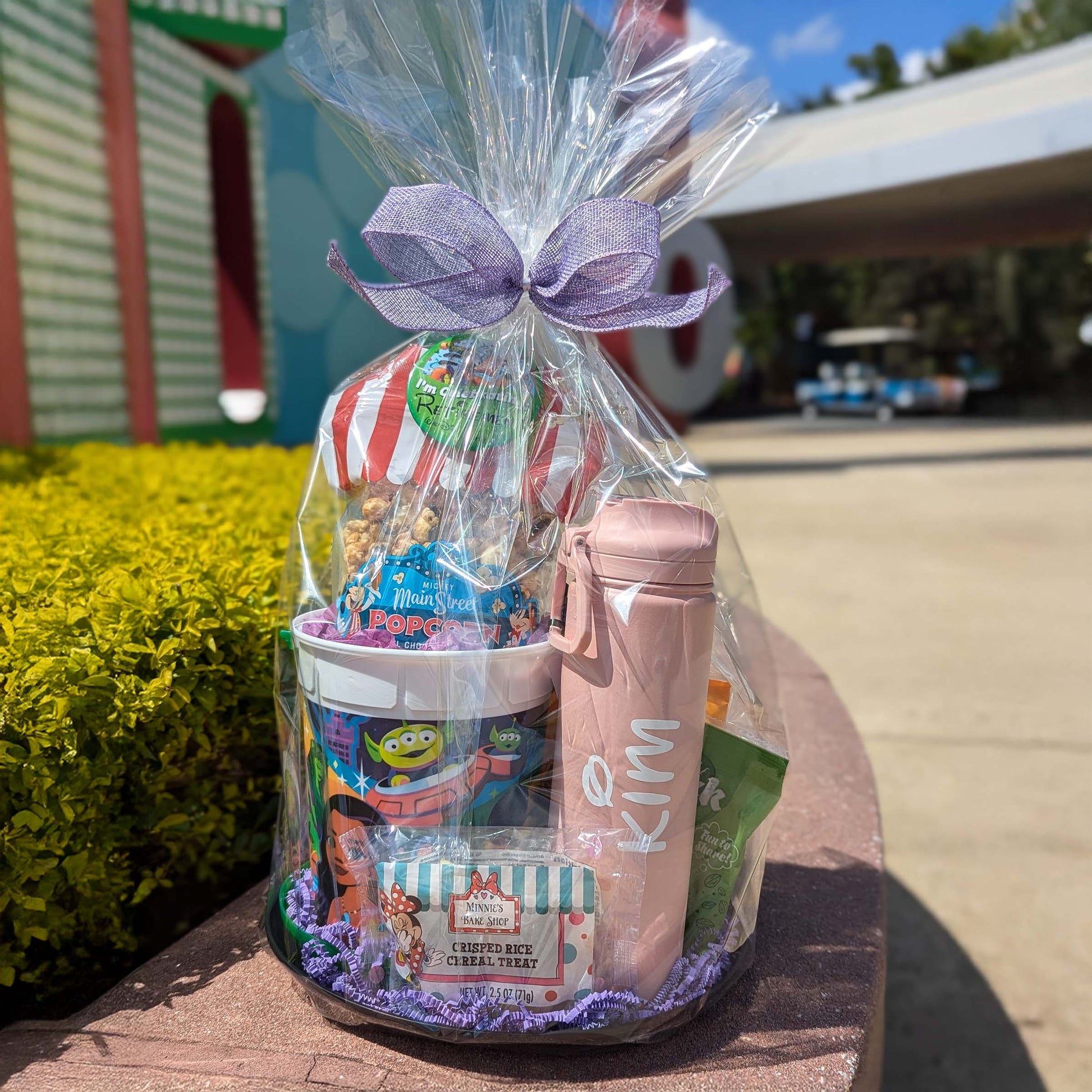Disney Parks refillable popcorn bucket and personalized water bottle in a gift basket, perfect for Walt Disney World resort deliveries in Orlando