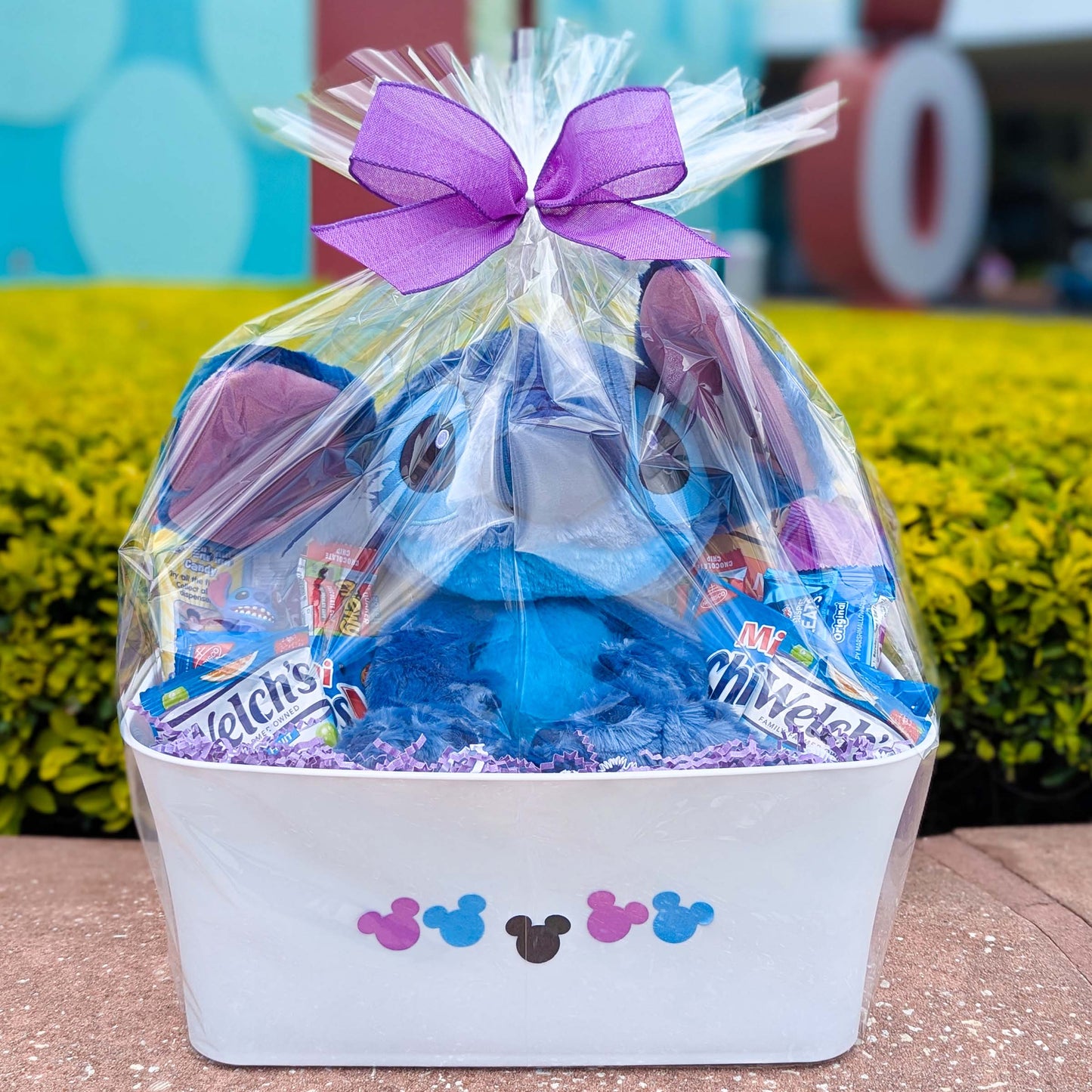 Custom Disney Stitch gift basket filled with an 11-inch licensed Disney Parks Stitch Big Feet plush toy, Welch's fruit snacks, and sweet treats for Orlando resort delivery
