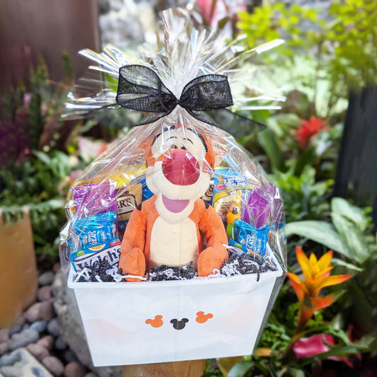 Custom Winnie the Pooh Tigger plush toy gift basket filled with sweet and salty snacks, bottled beverages, and a collectible PEZ dispenser for Orlando resort delivery