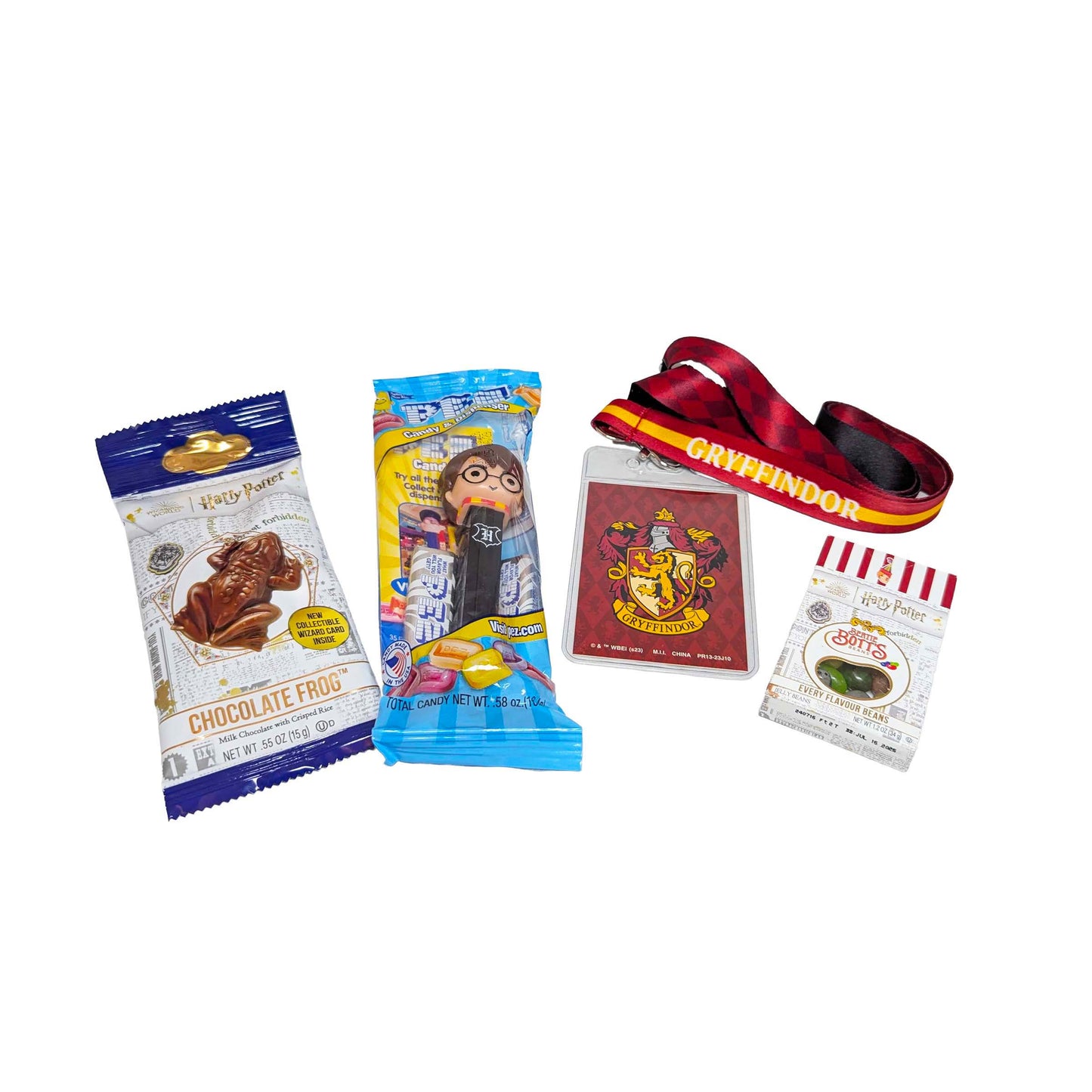 Flat lay arrangement of a Gryffindor house lanyard, a Chocolate Frog, themed PEZ dispenser, and Bertie Bott's Every Flavor Beans for an Orlando resort gift box