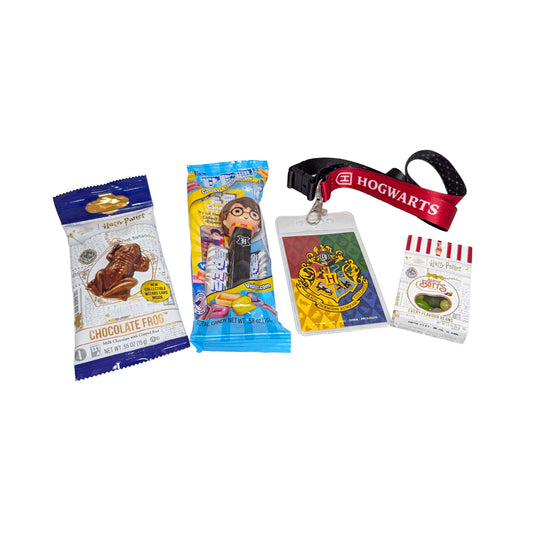 Flat lay arrangement of a Hogwarts themed lanyard, a Chocolate Frog, themed PEZ dispenser, and Bertie Bott's Every Flavor Beans for an Orlando resort gift box