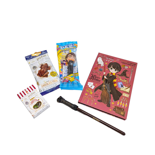 Flat lay arrangement of a licensed Harry Potter chibi journal, wand pen, a Chocolate Frog, themed PEZ dispenser, and Bertie Bott's Every Flavor Beans for a custom Orlando resort gift box