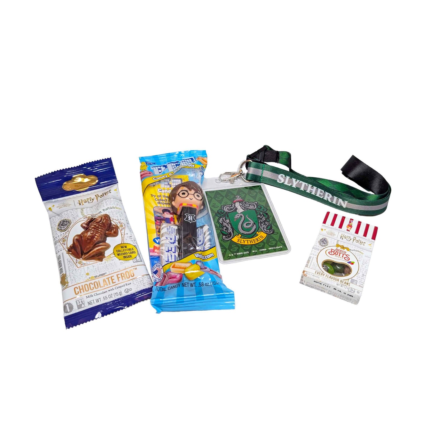 Flat lay arrangement of a Slytherin house lanyard, a Chocolate Frog, themed PEZ dispenser, and Bertie Bott's Every Flavor Beans for an Orlando resort gift box