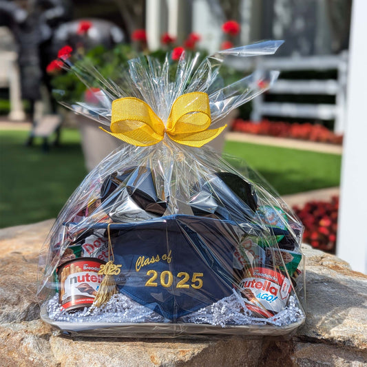 Mickey Mouse graduation themed gift basket featuring a Class of 2025 ear cap and snacks wrapped in clear plastic with a yellow bow