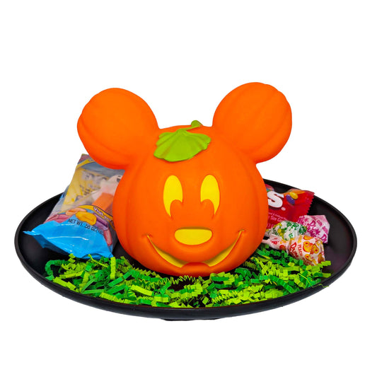 Mickey Mouse light-up Jack-o'-Lantern gift basket filled with Halloween candy on a black tray with green crinkle paper