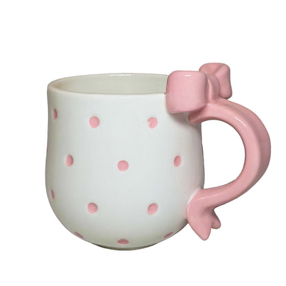 White ceramic mug with pink polka dots and a matching pink handle, perfect for themed Orlando resort gift baskets