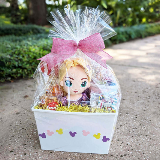 Rapunzel themed gift basket containing a plush toy, snacks, and a PEZ dispenser, wrapped in decorative paper with a bow, perfect for Walt Disney World vacation surprises