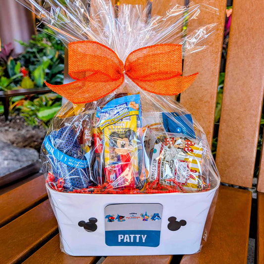 runDisney themed motivational gift basket filled with sports snacks and hydration drinks wrapped in clear cellophane with a large orange bow